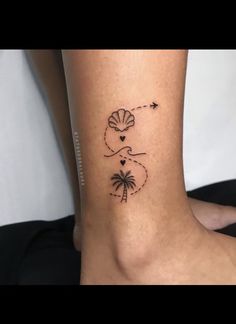 a woman's foot with a small palm tree and an arrow tattoo on it