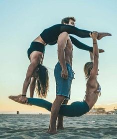 two people doing acrobatic tricks on the beach