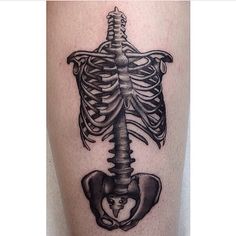 a black and white photo of a skeleton tattoo on the leg, with an arrow in the ribcage