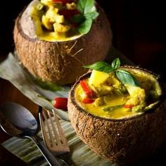 two coconuts filled with food on top of a table