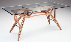 a glass table with wooden legs and an x - leg base, on a white background