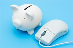 a white piggy bank sitting next to a computer mouse on a blue table top