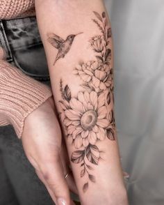 a woman's arm with flowers and a bird on it