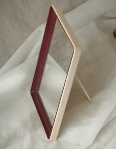 a small mirror sitting on top of a white sheet