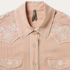 This blush rayon western shirt is crafted from soft, smooth 100% rayon crepe and features statement-making, retro-style cream piping and embroidery. It has single point front and back yokes, front faux pocket flaps, five-snap cuffs and a full snap front. Cut with an easy drape, in our flattering boyfriend fit which allows for comfort and freedom of movement. 1 Point Curved Front And Back Yokes Front Faux Pocket Flaps Cream Piping And Embroidery 5 Snap Cuff Boyfriend Fit 100% Rayon Imported Pink Western Top, Western Shirt Embroidery, Cutesy Paintings, Cowgirl Witch, Cowboy Fits, Retro Western Aesthetic, Womens Western Tops, Horsemanship Shirt, Embroidered Western Shirt