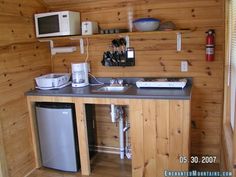 a small kitchen with wood paneling and stainless steel appliances on the counter top,