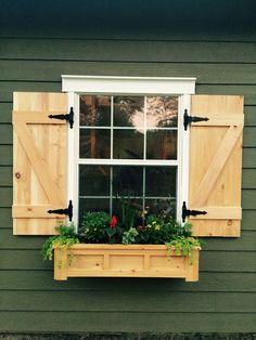 an open window with wooden shutters and flower boxes