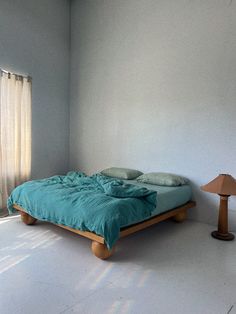 a bed sitting in the middle of a room next to a lamp