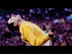 a man in yellow shirt and white pants doing a trick on a skateboard at a sporting event