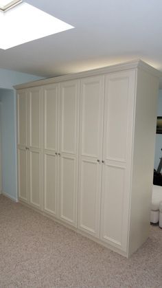 an empty room with white closets and carpeted flooring is pictured in this image