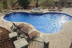 an above ground swimming pool surrounded by patio furniture and fire pit with seating around it