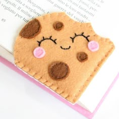 a bookmark made to look like a cookie with eyes and nose on it's side