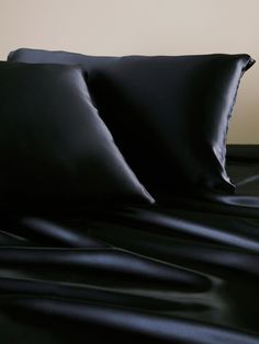 two black pillows sitting on top of a bed