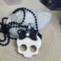 Skull Head Pendant Necklace on a Black Ball Chain: Made of hard plastic and metal pieces these skull pendant necklaces are awsome for the lil gothic girl in you....or in someone that you know. White with a Black Bow Has cute little rhinestone accents on the bow. Black Ball Chain measures 18 inches. Everything is Nickel and Lead Free! White Gothic Skull Jewelry, Edgy White Jewelry For Gifts, Metal Skull Print Necklace For Gift, Skull Print Metal Necklace For Gift, Punk Style Skull Print Necklace For Gifts, White Gothic Necklace Gift, White Skull Jewelry For Halloween, Halloween Skull Jewelry In White, White Skull-shaped Halloween Jewelry