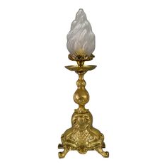 a golden candle holder with a white light on top