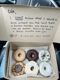 a box filled with donuts sitting on top of a car seat