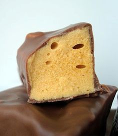 a piece of cake sitting on top of a chocolate covered bag with one bite taken out