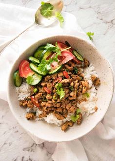 a bowl filled with rice, meat and veggies on top of a table