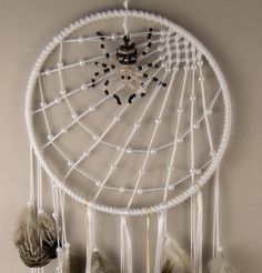 a white dream catcher hanging on the wall