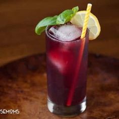 a red drink with lemon and mint garnish