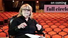 a woman sitting in a chair holding a piece of paper with the words full circle on it