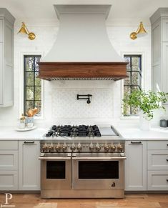 a stove top oven sitting inside of a kitchen next to white cabinets and counter tops