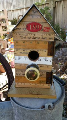 a wooden birdhouse with measuring tape around it