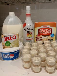 the ingredients to make an ice cream dessert are displayed on a counter top, including milk, yogurt, and graham crackers