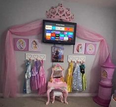 there is a tv that is on in the corner of this room with princess dresses