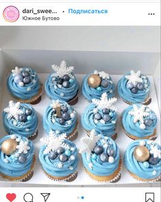 a box filled with blue frosted cupcakes on top of a white table