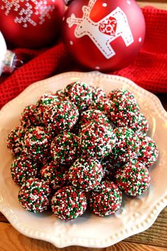 a white plate topped with christmas sprinkle covered cookies