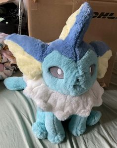 a blue stuffed animal sitting on top of a bed