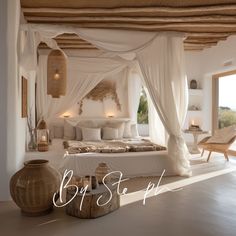 a white bed sitting under a canopy next to a window