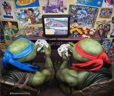 two teenaged turtles playing video games in front of a tv