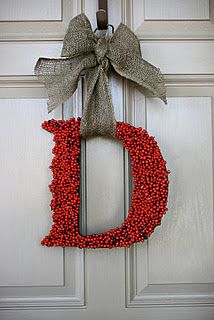 a wreath with the letter d hanging on a door