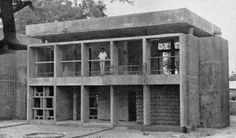 an old black and white photo of a man standing on the balcony of a building