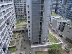 an aerial view of two buildings in a city with grass on the roof and walkways