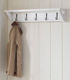 a coat rack with two coats hanging from it's hooks on a white wall