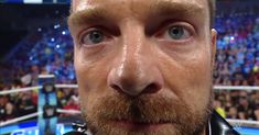 a close up of a man with a goatee in front of a crowd at a sporting event