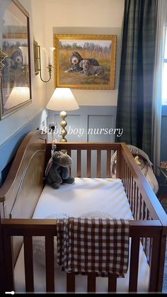 a baby crib with a teddy bear in it and two pictures on the wall