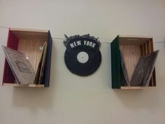 there are three boxes with records in them on the wall next to a record player