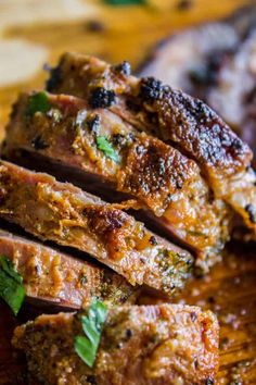 sliced meat on a cutting board with herbs