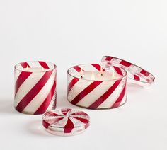 three red and white striped candles sitting next to each other