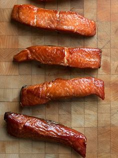 three pieces of smoked salmon on a cutting board