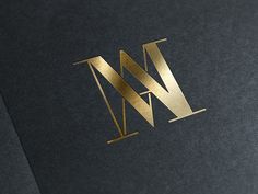 the letter w is made out of gold foil and has a black background with golden lettering