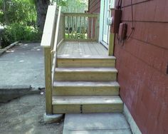 there is a set of stairs leading up to the door and side of a house