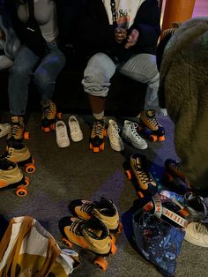 a group of people sitting around with shoes on the floor and one person holding a cell phone