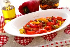 a white plate topped with red peppers and olives