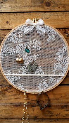 a white doily hanging on a wooden wall next to scissors and other items in front of it