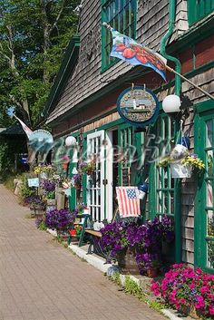 the outside of a store with flowers and flags